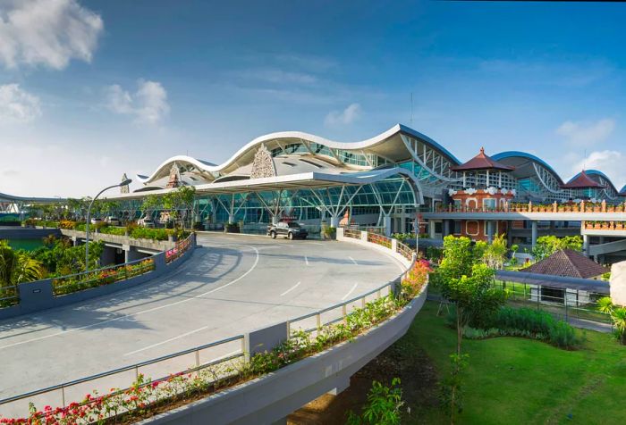 A contemporary airport exterior featuring expansive dome roofs and traditional pavilions on one side.