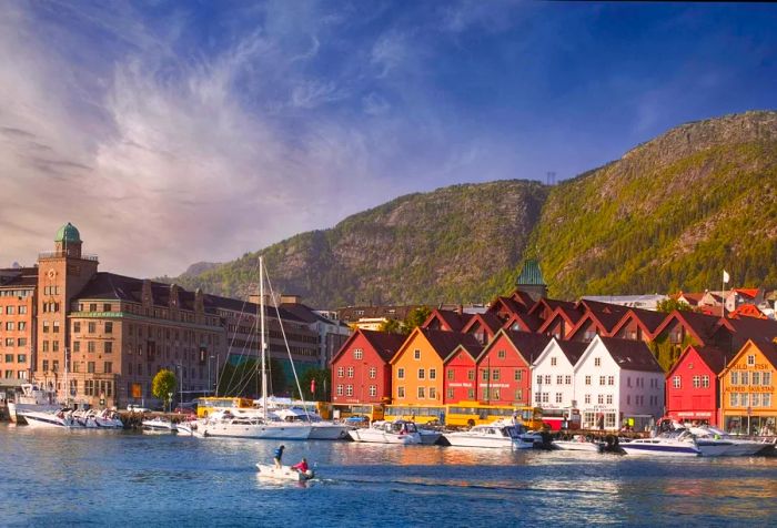 Colorful, compact buildings line the foot of the mountain, framing the boats docked in the harbor.