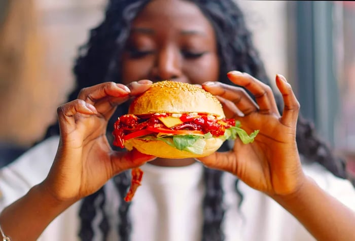 A woman enjoys her delicious burger.