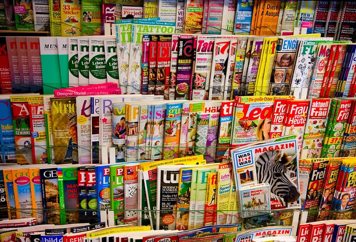 Shelves stocked with vibrant magazines in a rack.