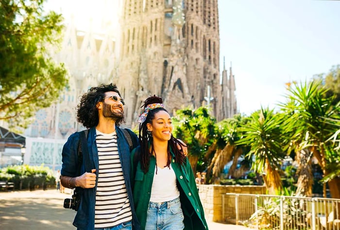 A couple strolls along a street with the iconic Sagrada Familia in the background, Barcelona, Spain