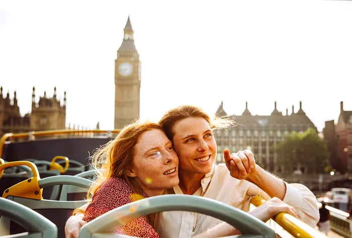 An LGBTQ couple enjoying an open-top bus tour in London, England, United Kingdom.