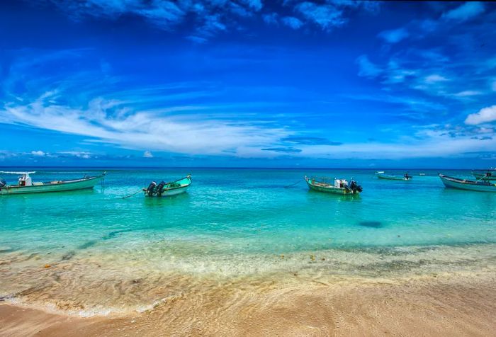 Silent fishing boats gently anchored at the shore, with the endless sea extending to the horizon, while swirling clouds added drama to this serene landscape.