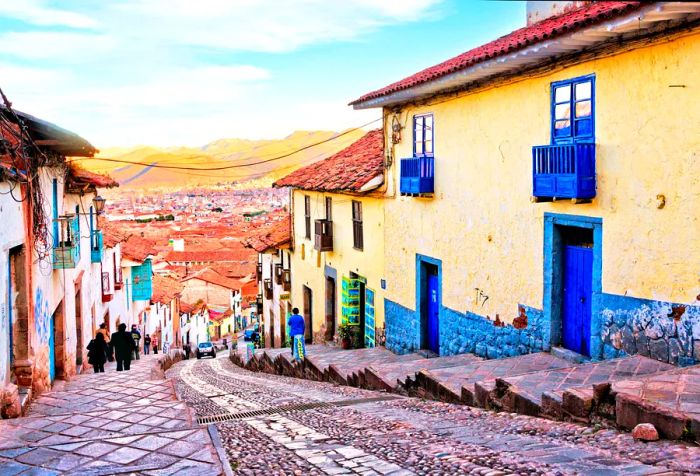 A quaint village where locals stroll past buildings lining a stone-paved, stepped street.