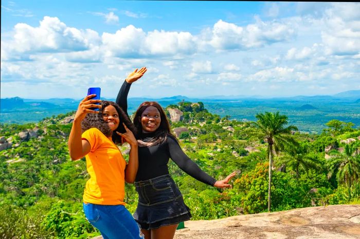 A group of young African women enjoying a hike in nature, taking selfies together