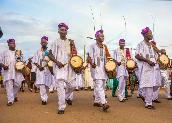 Drummers dressed in white perform on the street