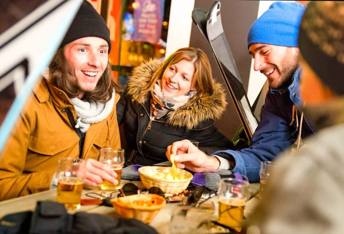 A group of friends joyfully chatting over beers and snacks.