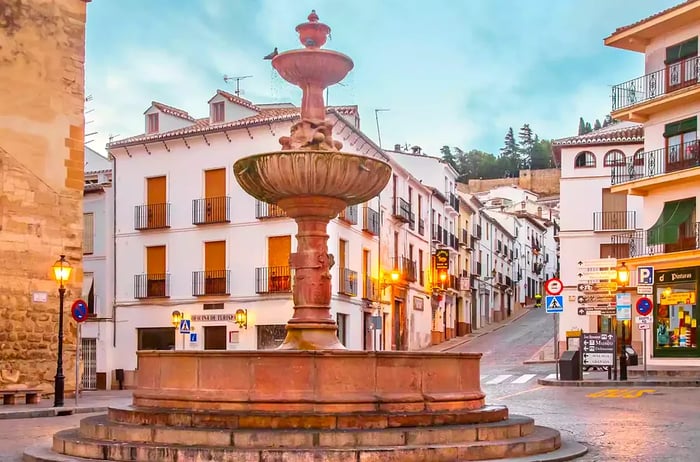 Spain, Málaga Province, Antequera. A picturesque view of San Sebastian Square in the heart of the city, showcasing the eponymous church and the street leading to the historic Arabic fortress, Alcazaba, in the backdrop.