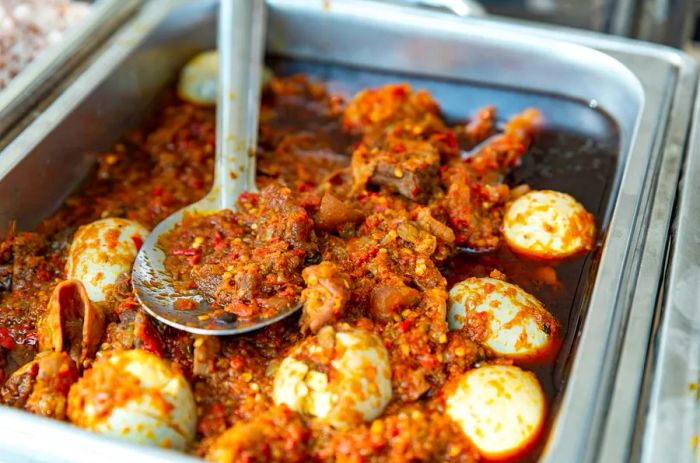 A spoon resting in a generous serving of stew at a canteen