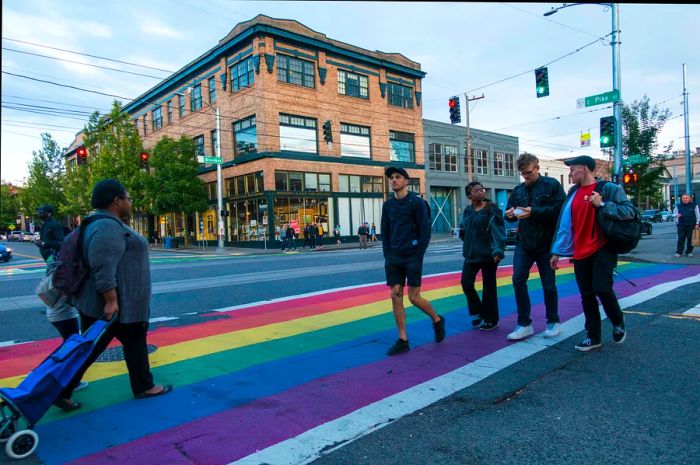 Pedestrians navigate a rainbow crosswalk on Capitol Hill at the intersection of East Pike St and Broadway.