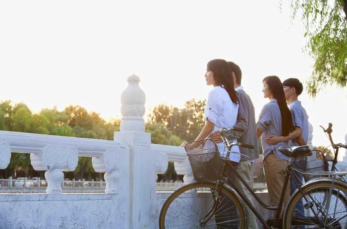 Two couples on bikes enjoy the picturesque view of Houhai Lake, Beijing