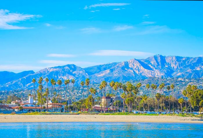 A coastal cityscape with a backdrop of majestic mountains.