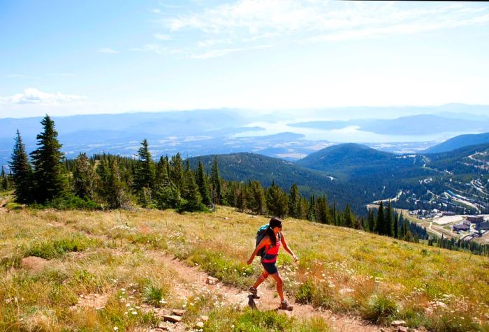 A woman hikes up Mt. Schweitzer, taking in views of Sandpoint, Idaho, and Lake Pend Oreille.