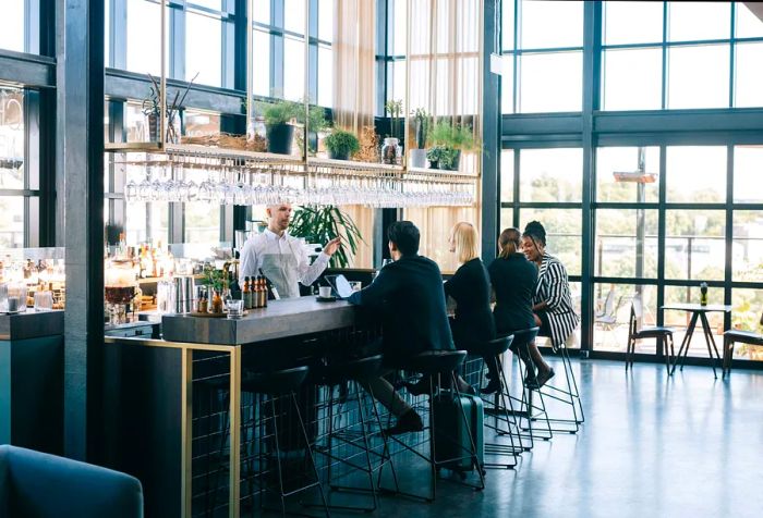 Group of travelers enjoying the business class lounge at the airport bar.