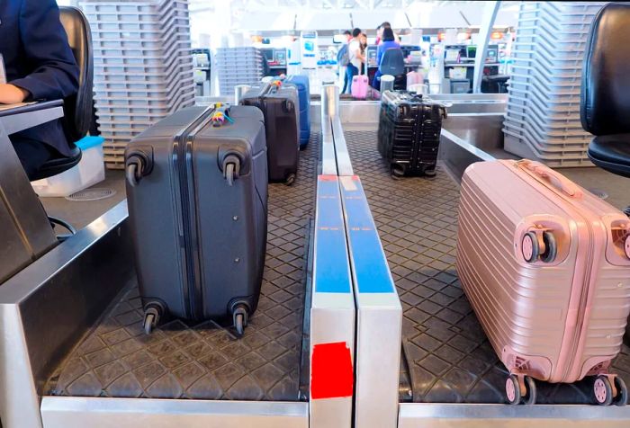 Vibrant pieces of luggage waiting at the check-in counter.