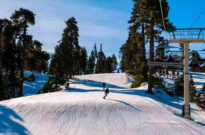 Snowboarders carving down a slope at Bear Mountain Ski Resort, Big Bear Lake, California