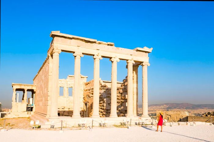 A woman gazing at the ruins of a temple on the Acropolis in Athens, Greece