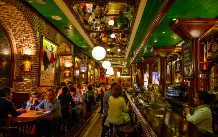 Diners enjoying their meals at the Tirso de Molina restaurant in Madrid, Spain