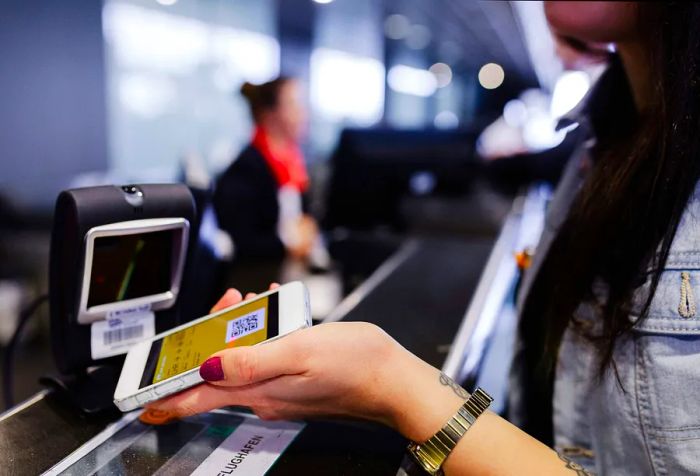 A modern traveler smoothly checks in for their flight, confidently showing their mobile boarding pass.