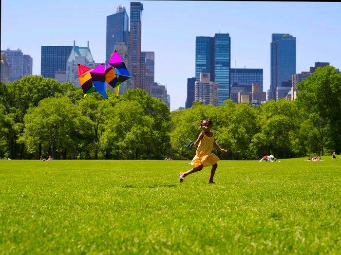 A young girl flying a kite in Central Park