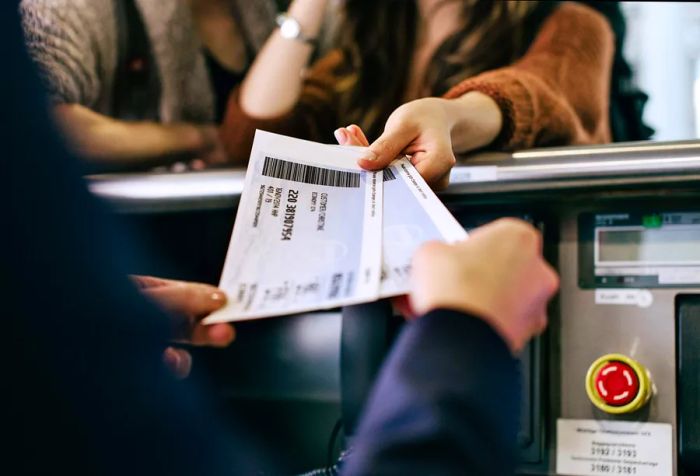 A woman presenting her boarding passes at the check-in counter.