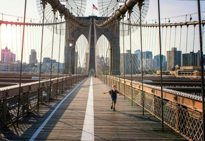 Child sprinting across Brooklyn Bridge, New York City