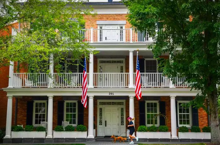 A person jogs alongside their dog in front of The Inns of Aurora in New York.