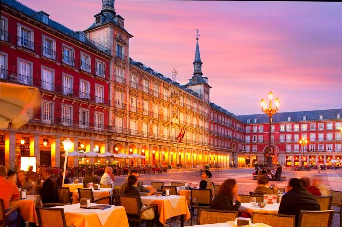 Diners enjoying the evening at tables outside in Madrid's Plaza Mayor