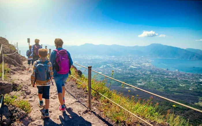 A family stands at the summit of Mount Vesuvius, gazing out over the Bay of Naples.
