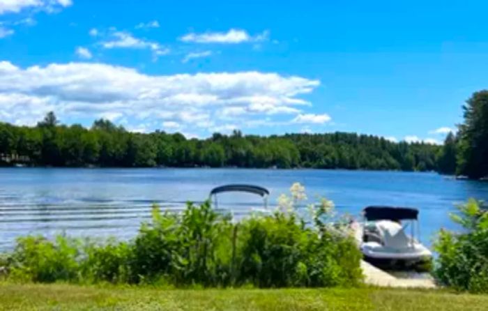 Lakeside dock with two boats in the summer in Wolfeboro, NH