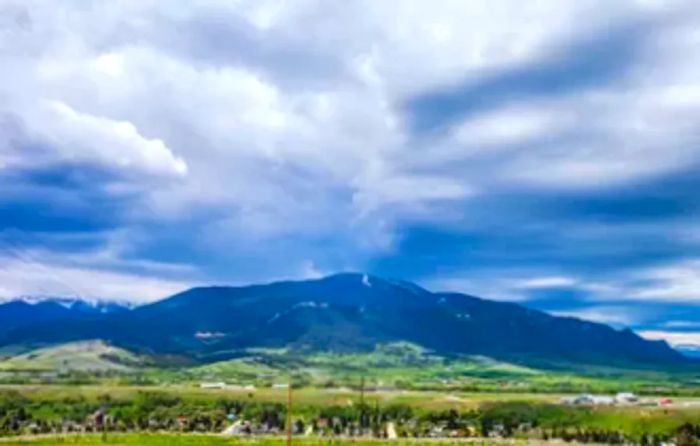 Cloudy skies loom over the mountains with a view of Red Lodge, Montana below