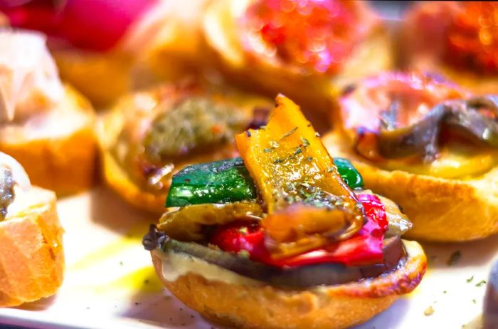 A close-up of peppers atop bread, showcasing one of Venice's traditional 'cicchetti' snacks.