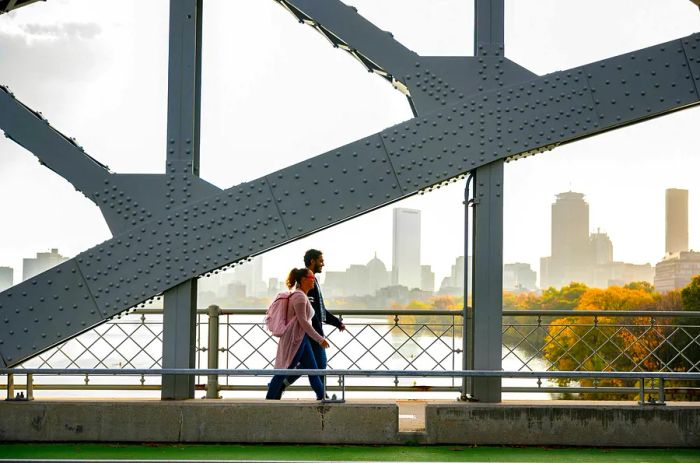 African American students walking across a bridge in Boston, with the city skyline visible in the background.