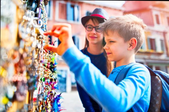 Children exploring souvenirs at an outdoor market in Venice