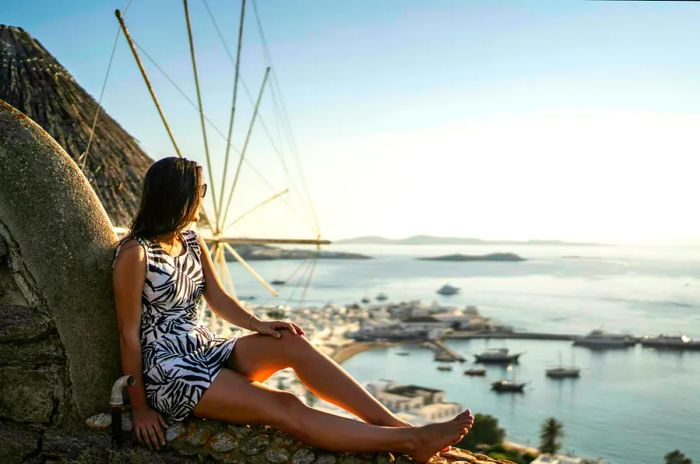 Young woman sitting and enjoying the view of the sea