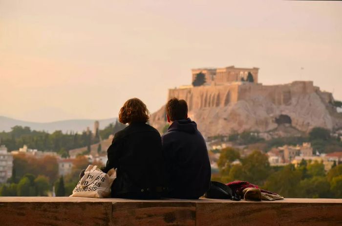 Rear view of a man and woman admiring buildings against the sky