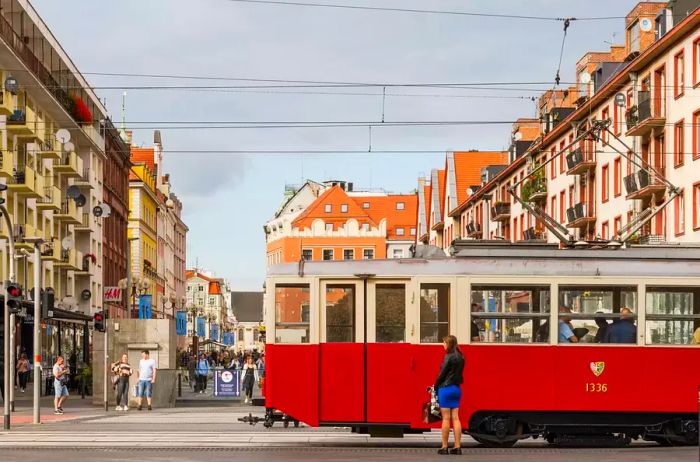 A red tram navigates the streets of Poland.