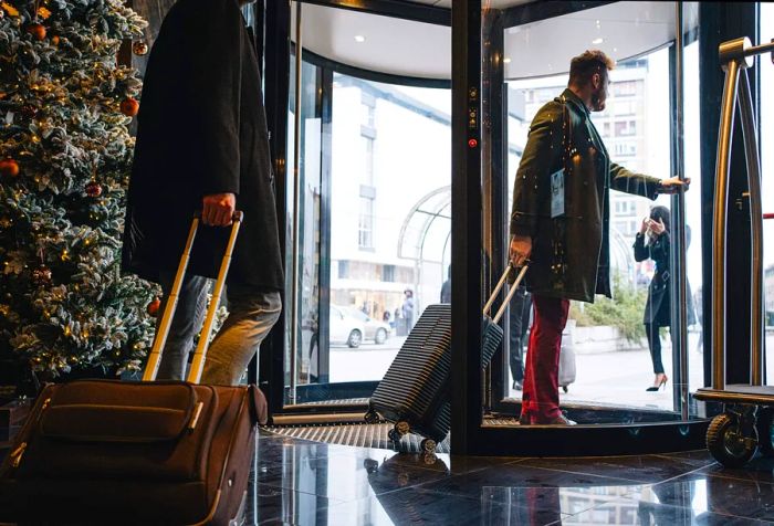 Businessmen exiting a hotel through a revolving door.