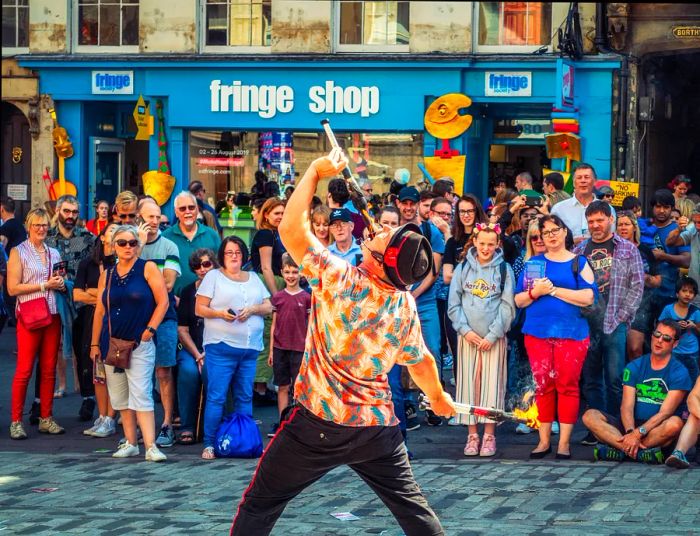 Crowds gather to watch a fire-eating street performer during the Edinburgh Festival in Edinburgh, Scotland, United Kingdom