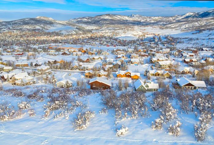 A quaint rural village where a cluster of homes is blanketed in deep snow.