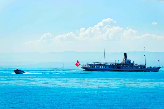 A large ferry carrying passengers glides across a lake.