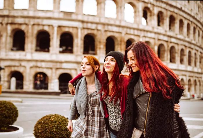 Visitors dressed for winter stroll alongside the iconic Roman Colosseum.