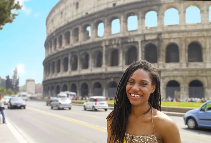 A smiling woman stands before the Colosseum on a bright summer day.