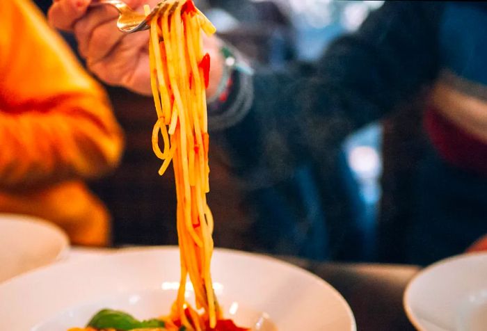 A fork twirls strands of spaghetti noodles.