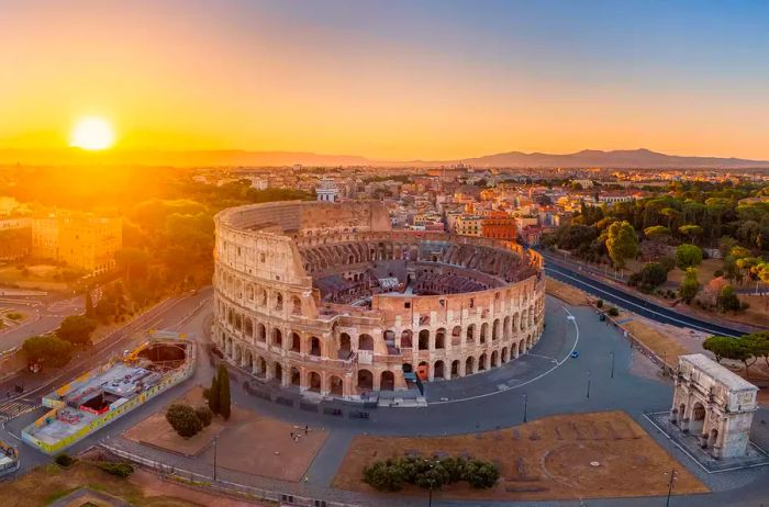 Aerial perspective of the Colosseum alongside the cityscape of Rome.