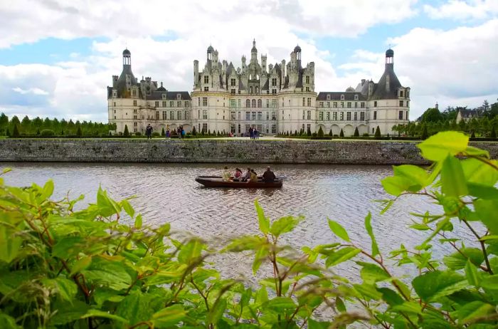 Visitors enjoy a boat ride as they glide past the magnificent Chambord castle.