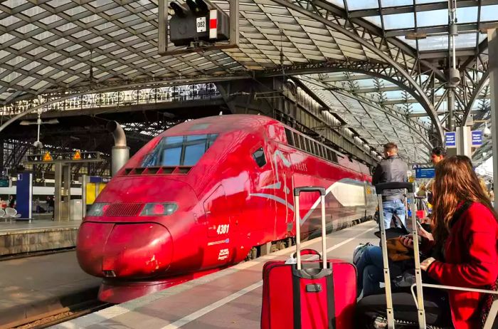 Thalys High-Speed Train at the French station Hautbahnhof Hbf, with passengers on the platform awaiting their departure.