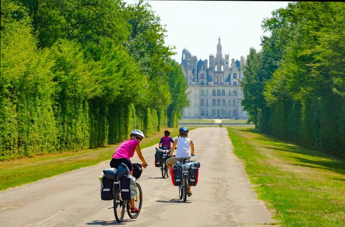 Bikers touring with panniers near Chambord Castle in the Loire Valley, France