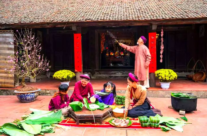 Vietnamese family members preparing Bánh Chưng together in a traditional courtyard. This cake is an essential dish found on the altar and at family meals during the Tết holiday.