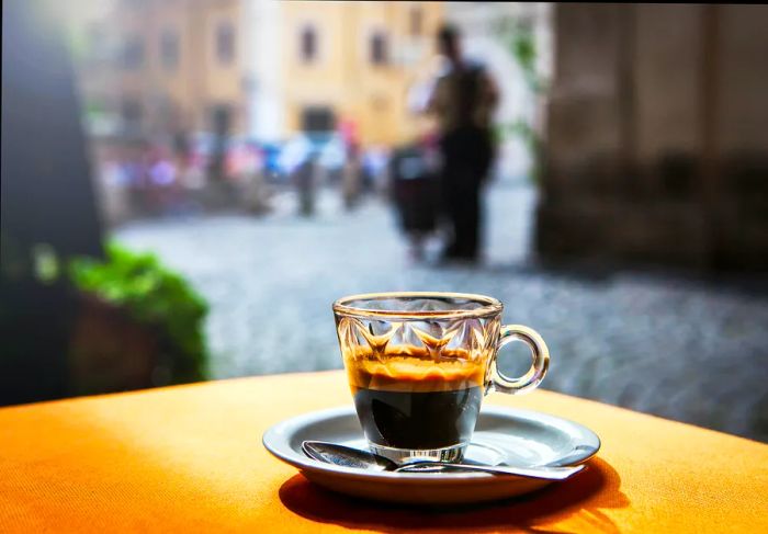 A steaming cup of espresso sitting on a cafe table